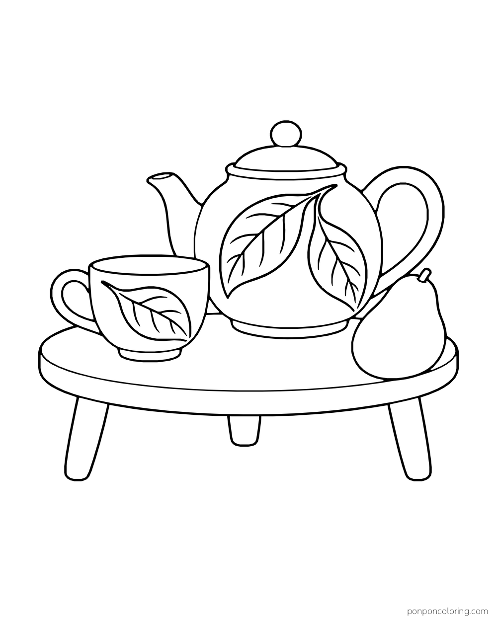 A ceramic teapot and matching cup with broad avocado-leaf motifs, beside one whole avocado on a low table.