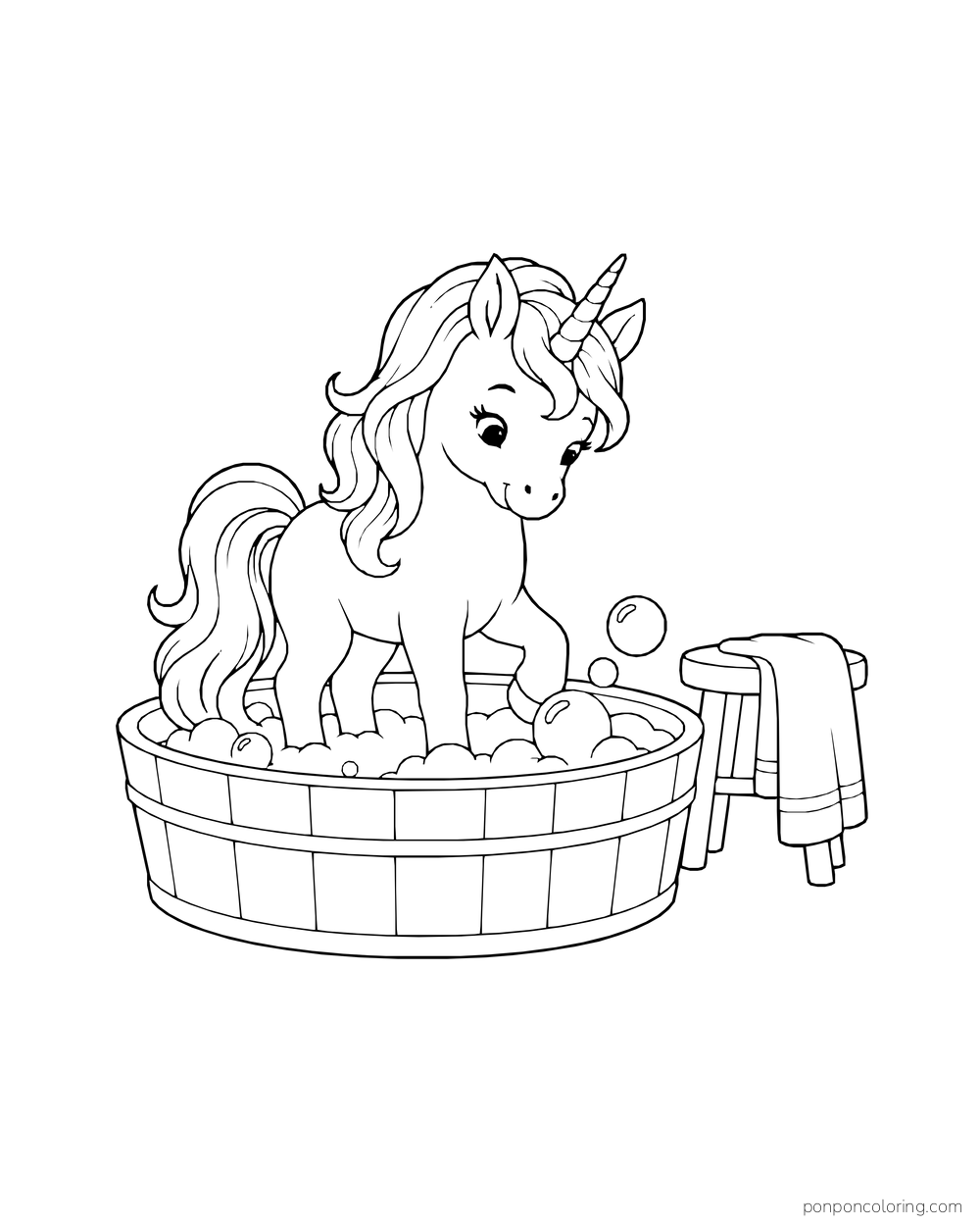 A young unicorn stands in a round tub full of bubbles beside a folded towel.