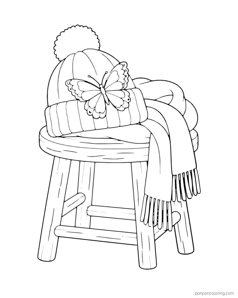 A butterfly rests on a knit hat and scarf arranged on a wooden stool.