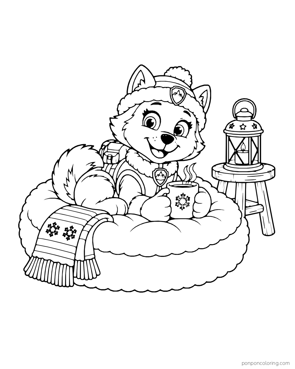 Everest holds a mug on a round cushion beside a lantern and a patterned scarf.