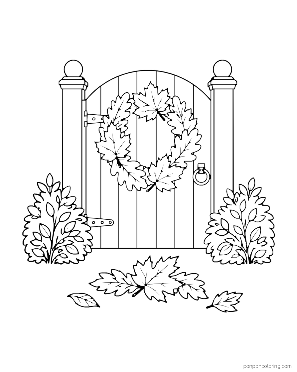 A leaf wreath hangs on a small gate between two shrubs, with fallen leaves below.