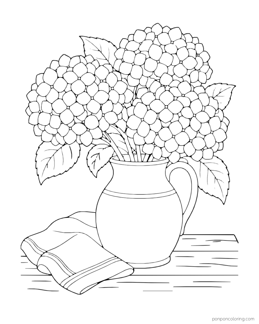 Three rounded hydrangea clusters fill a ceramic jug beside a folded cloth on a wooden surface.