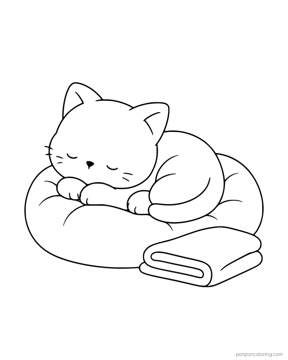 A kitten sleeping on a round cushion beside a folded blanket.