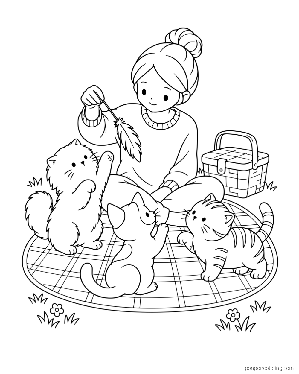 A woman holding a feather toy for three kittens on a picnic blanket beside a basket.