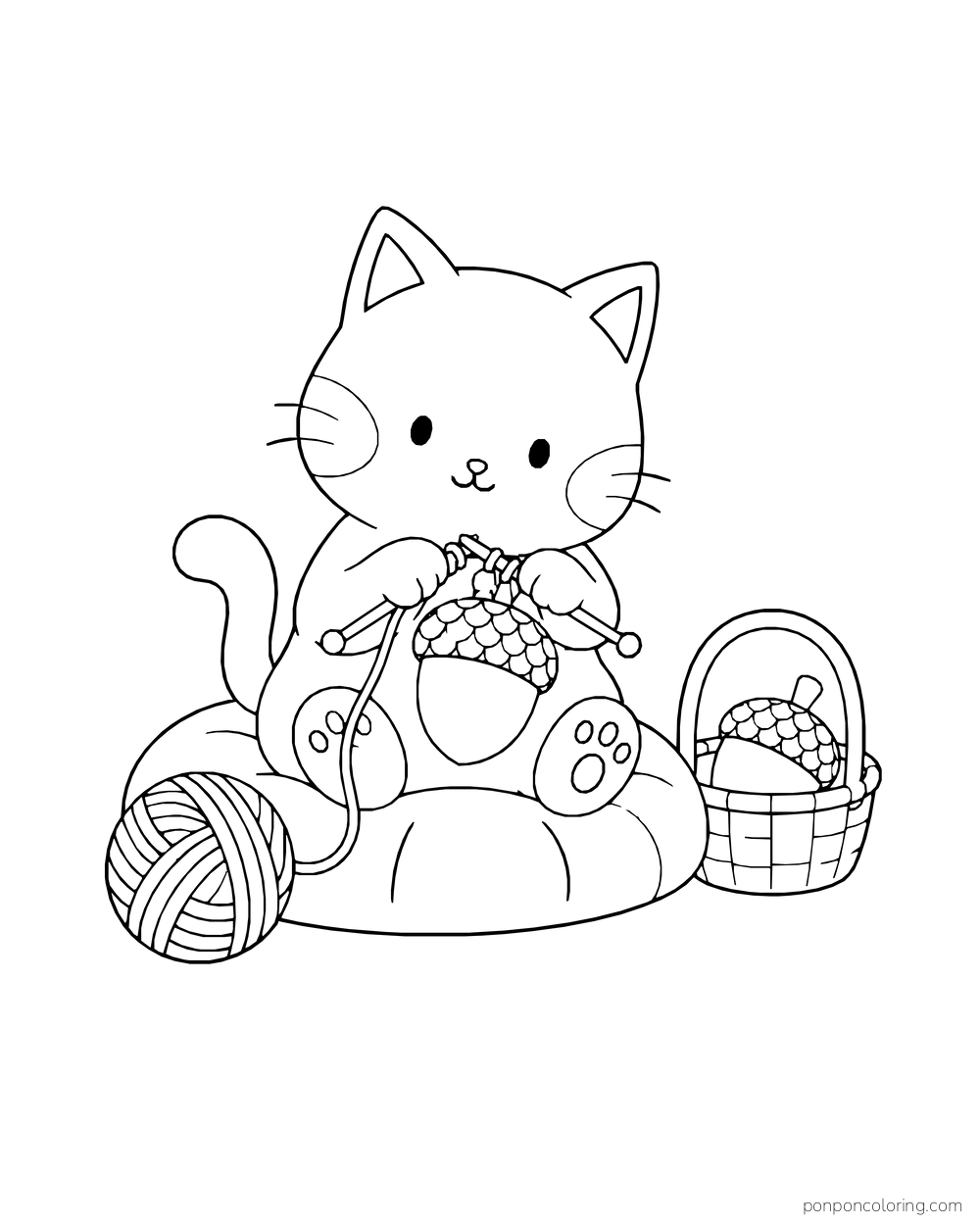 A kitten knits an acorn-shaped toy on a cushion beside a ball of yarn and a basket holding another acorn toy.