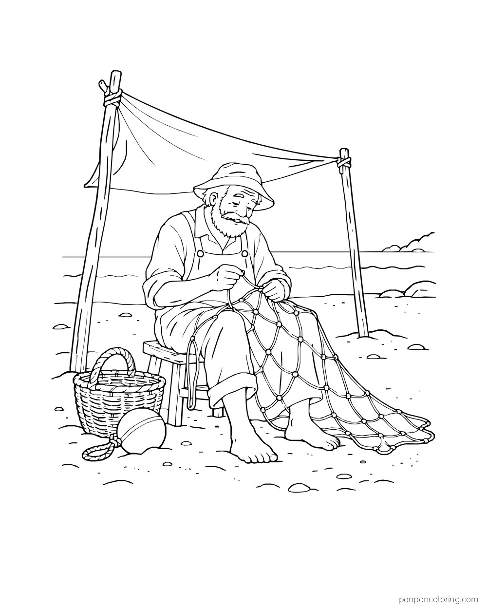 A seated man works on a fishing net beside a basket on the beach.