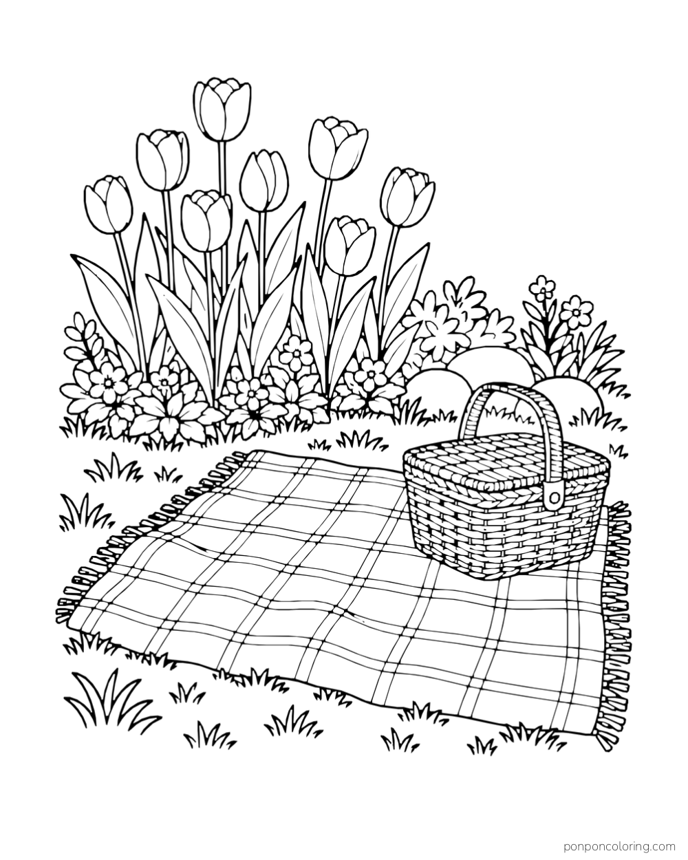 A checked picnic blanket and basket next to a bank of tulips.