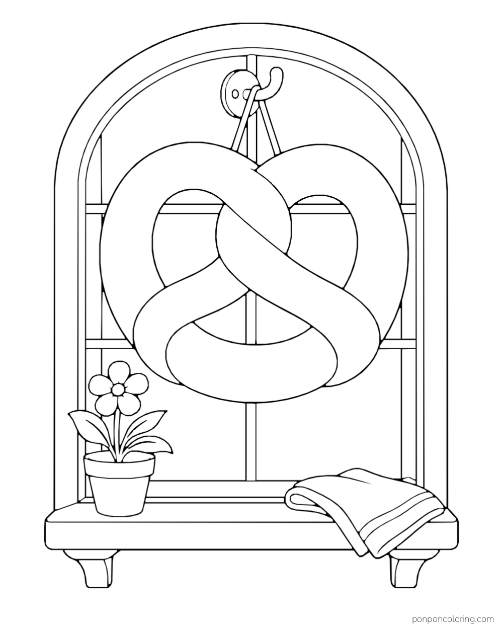 A large pretzel hangs in an arched bakery window above a flowerpot and folded cloth.