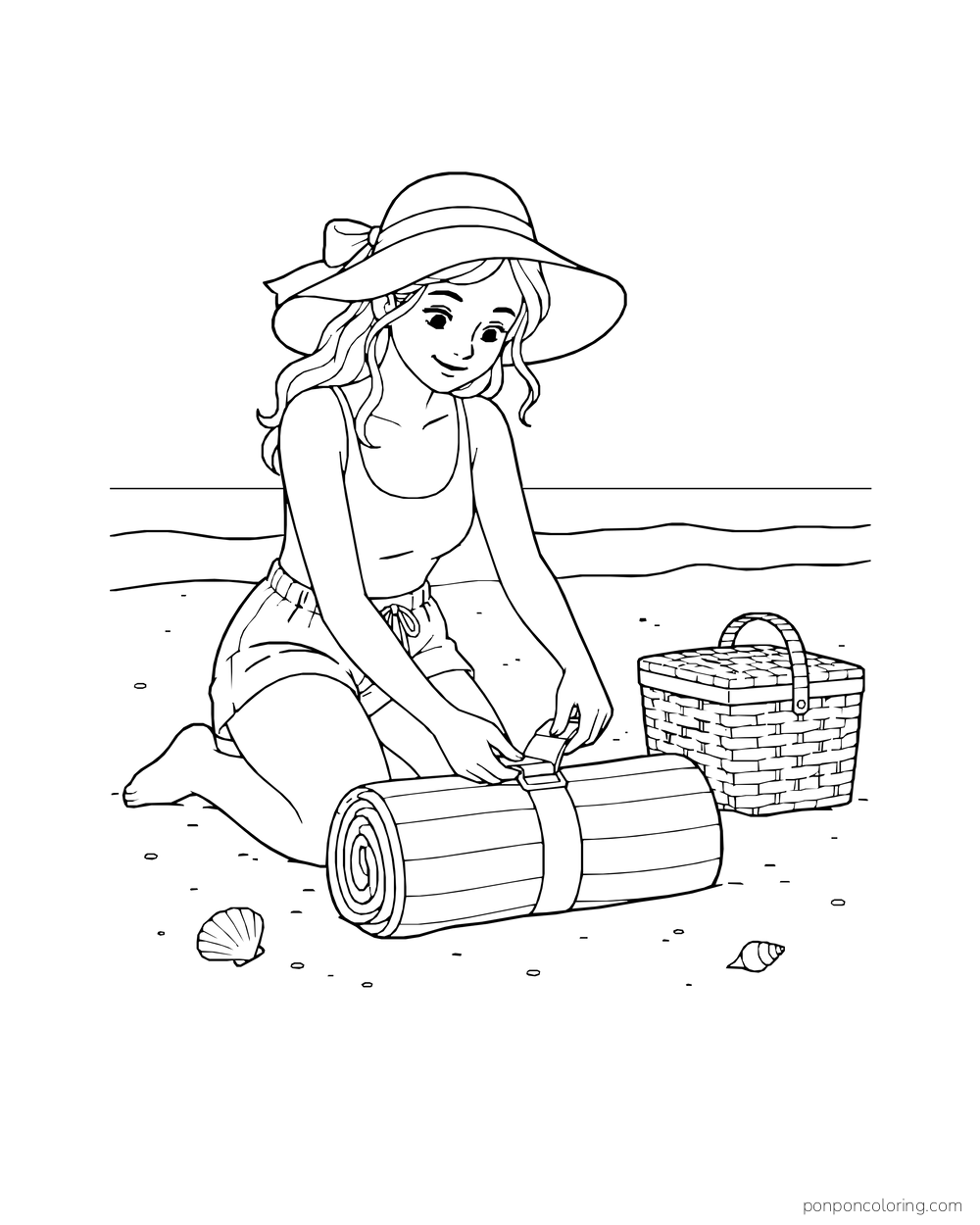 A beachgoer rolls and straps a blanket beside a basket.