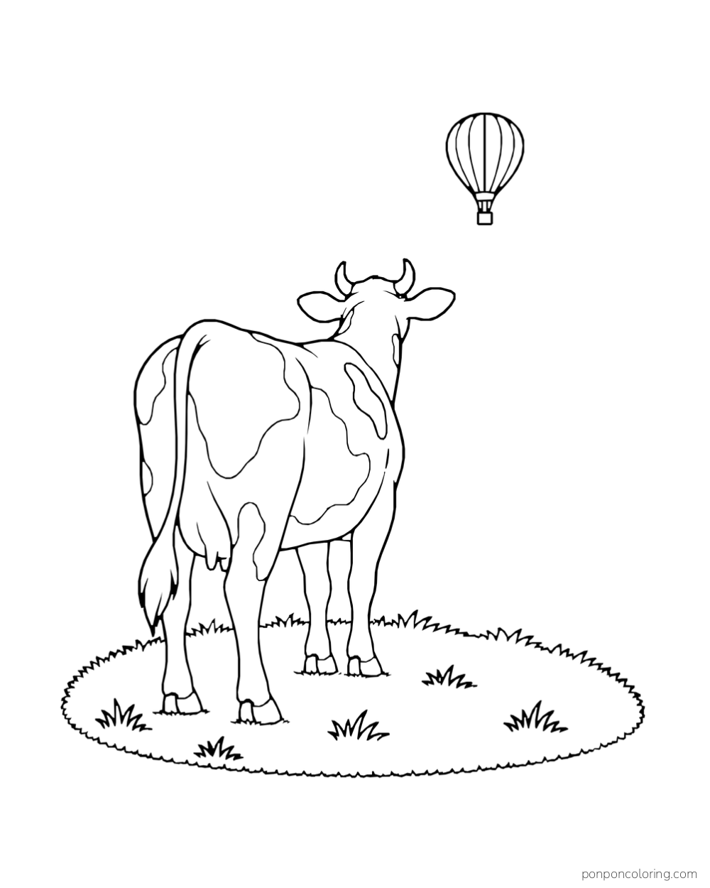 A cow viewed from behind watches a hot air balloon above a grassy patch.