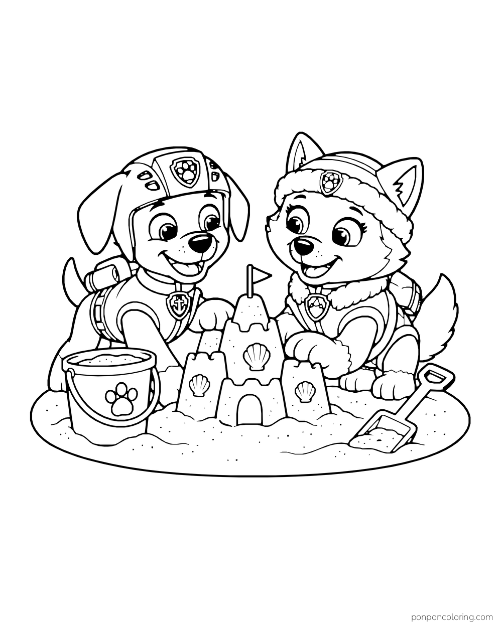 Zuma and Everest build a sandcastle with shells beside a bucket and shovel.